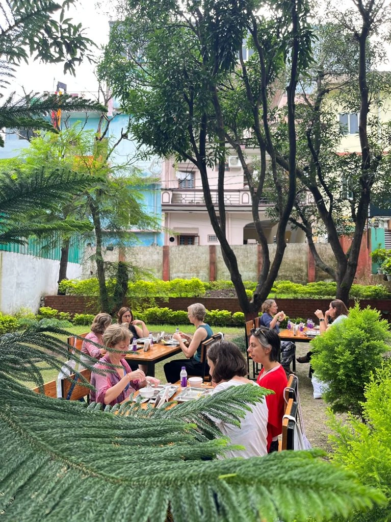 Students at lunch in the ashram garden at Tattvaa Yogashala