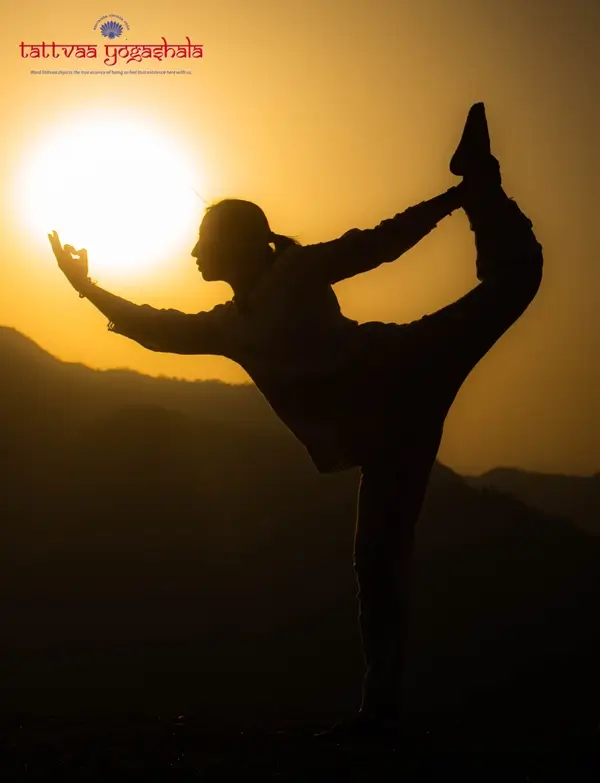 A student in natarajasana at sunset above Rishikesh