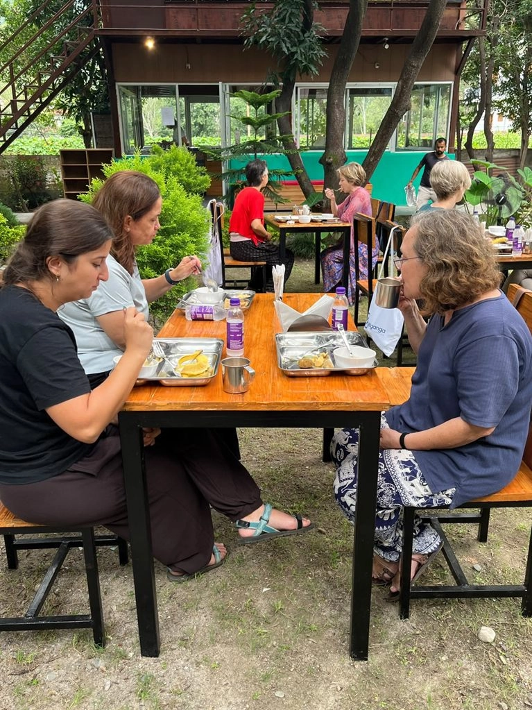 Students sharing a meal in the garden at Tattvaa Yogashala, Rishikesh