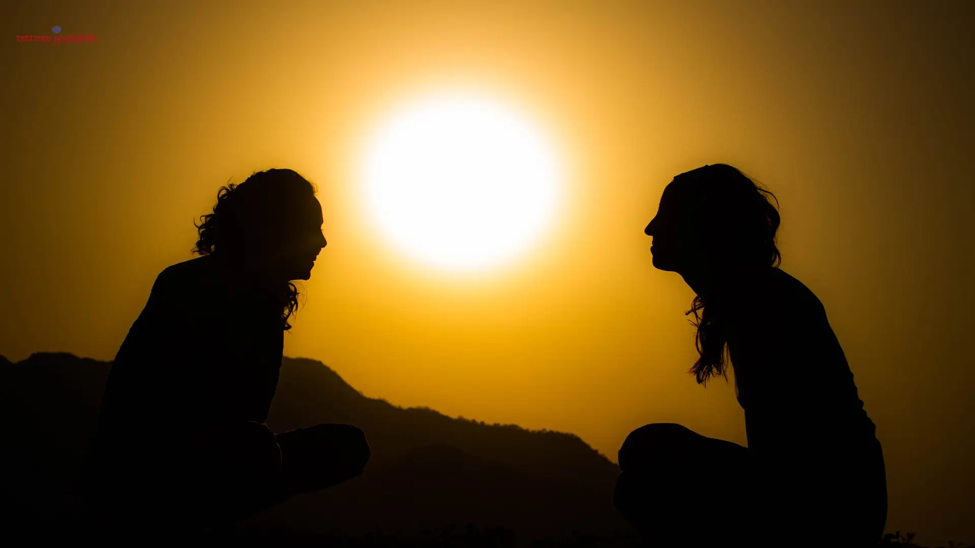 Two students sitting together at sunset above Rishikesh
