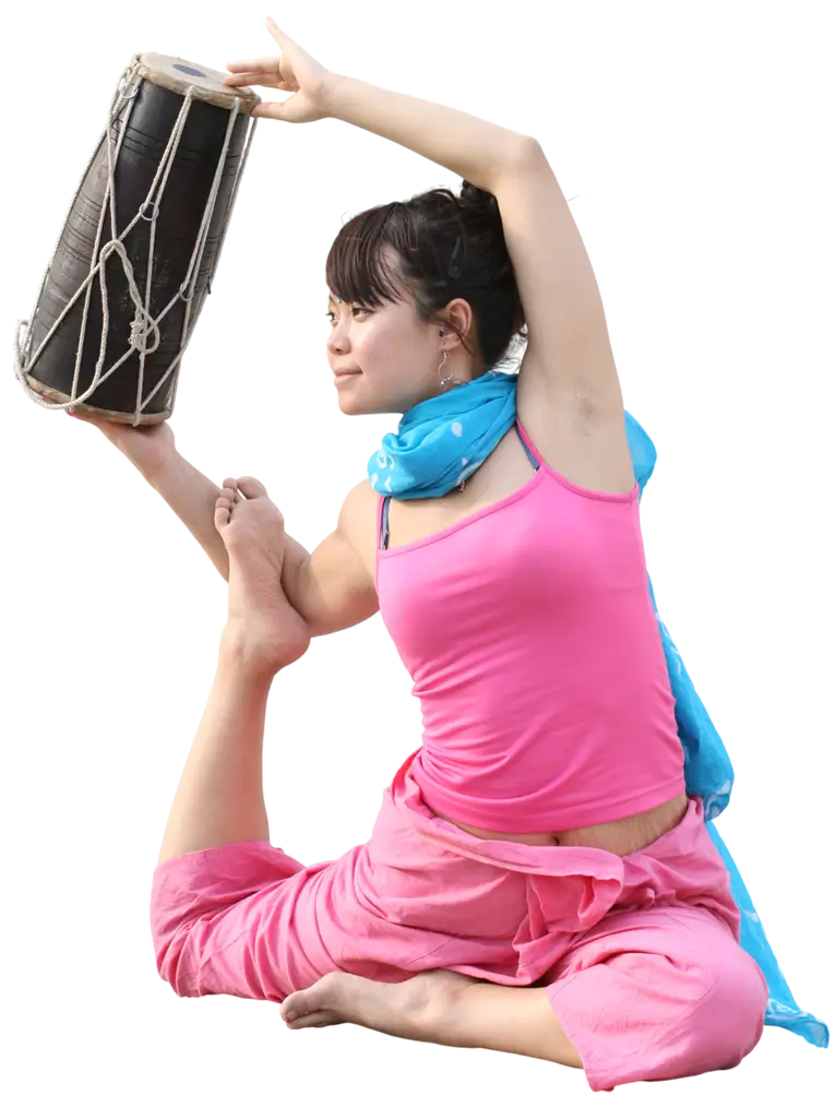 A student in a seated one-legged pigeon pose, holding a drum