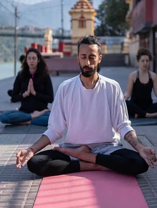 Students seated in meditation beside the Ganges during the 300 hour yoga teacher training at Tattvaa Yogashala, Rishikesh