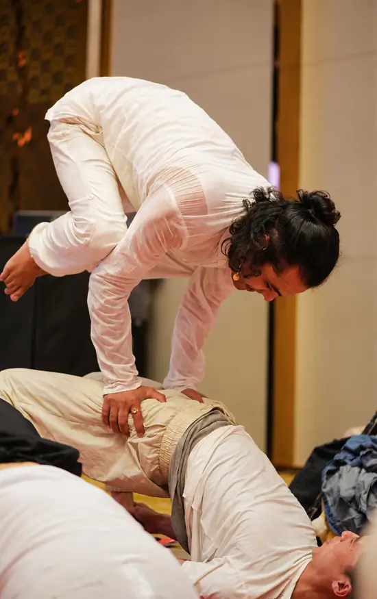A teacher giving a hands-on adjustment during an Ashtanga class at Tattvaa Yogashala